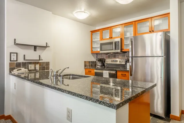 a kitchen with stainless steel appliances granite countertop a refrigerator and a sink