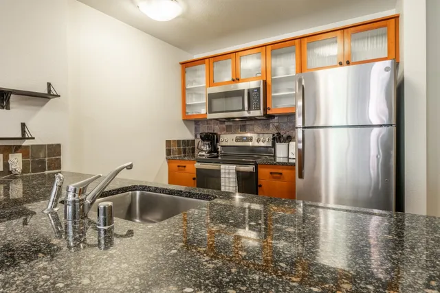 a kitchen with stainless steel appliances granite countertop a refrigerator and a sink