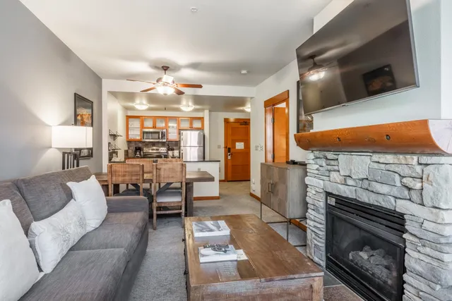 a living room with furniture a flat screen tv and a fireplace