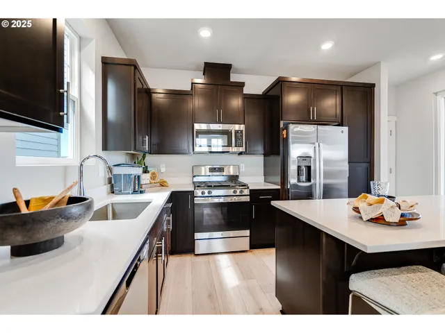 a kitchen with stainless steel appliances a sink stove and refrigerator