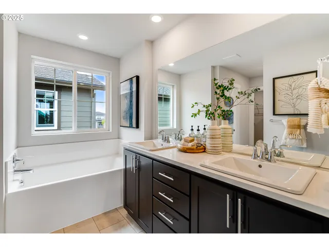 a bathroom with a sink double vanity granite tub shower and a mirror