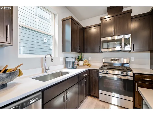 a kitchen with stainless steel appliances a sink stove and cabinets
