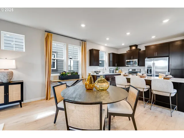 a kitchen with a table chairs refrigerator and cabinets