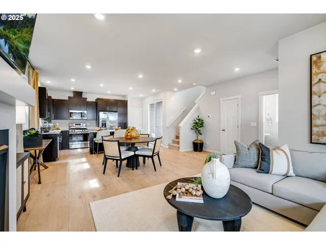 a living room with lots of furniture kitchen view and a table