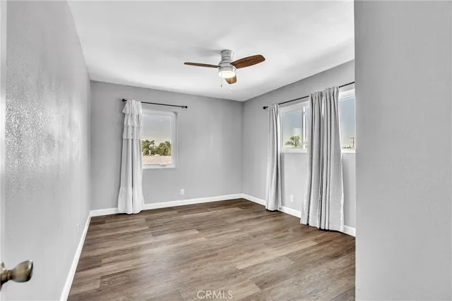 a view of a livingroom with wooden floor and a ceiling fan