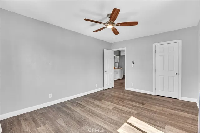 a view of a big room with wooden floor and windows