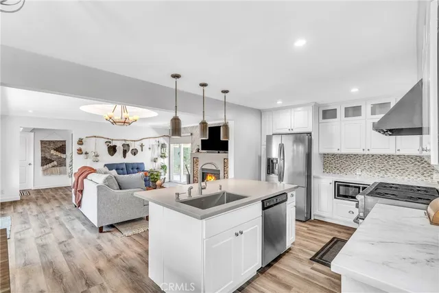 a kitchen with stainless steel appliances kitchen island granite countertop a stove and a refrigerator