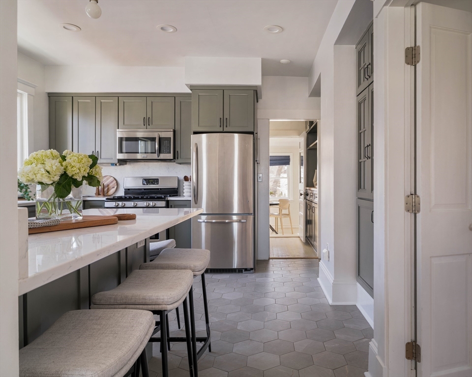 182 Maplewood Street, Unit 2 Watertown, MA 02472 - Photo 13 of 42 a kitchen with stainless steel appliances a refrigerator a sink a stove a dining table and chairs
