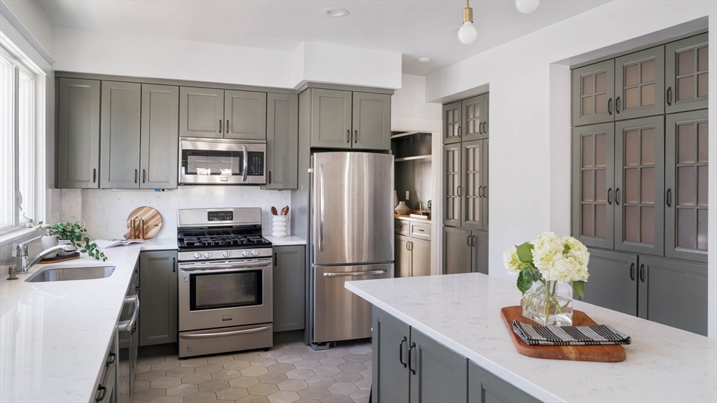 182 Maplewood Street, Unit 2 Watertown, MA 02472 - Photo 14 of 42 a kitchen with kitchen island stainless steel appliances a stove refrigerator sink and cabinets