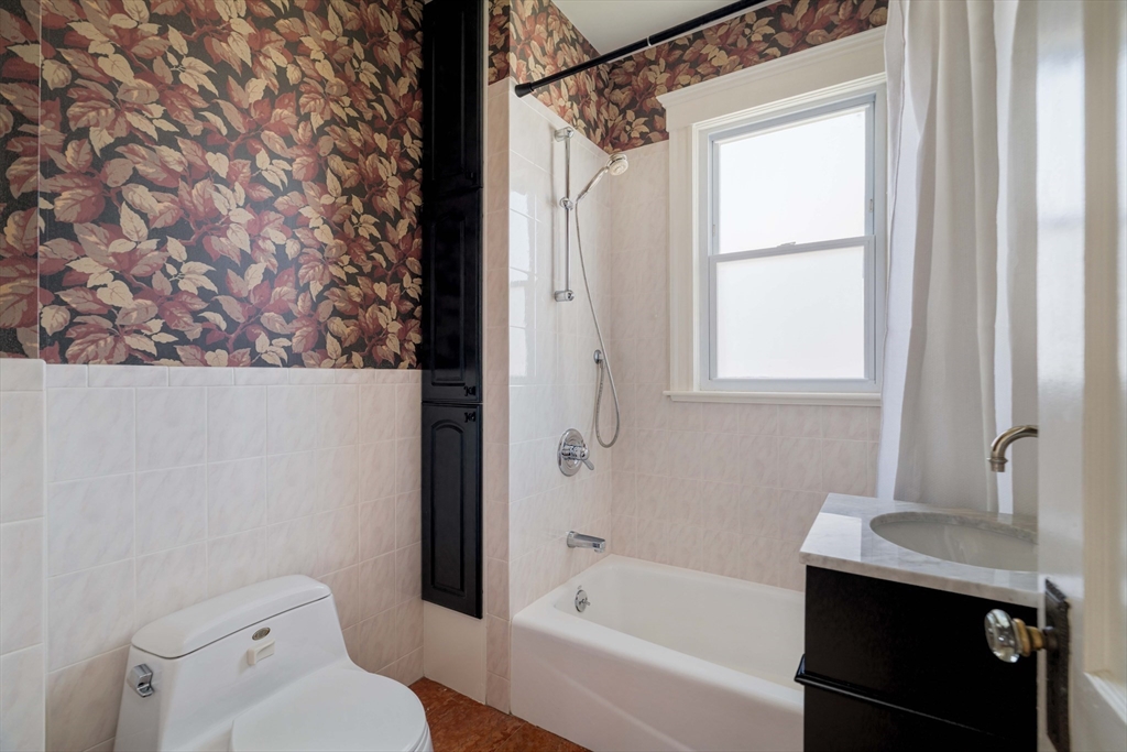 182 Maplewood Street, Unit 2 Watertown, MA 02472 - Photo 19 of 42 a bathroom with a granite countertop sink toilet and shower