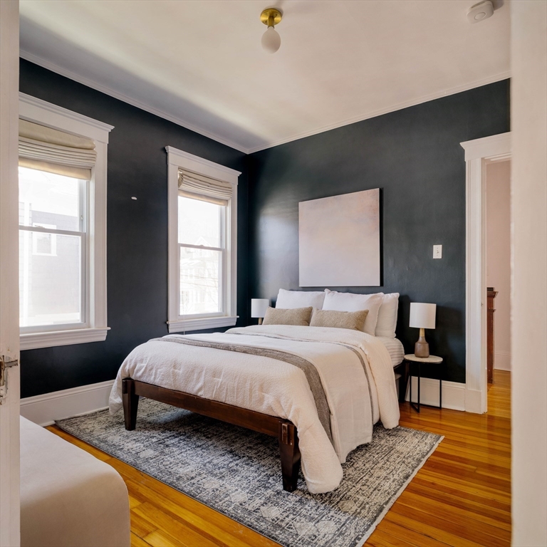 182 Maplewood Street, Unit 2 Watertown, MA 02472 - Photo 21 of 42 a bedroom with a bed and wooden floor