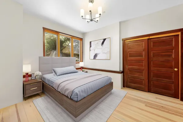 a bedroom with a large bed and a chandelier