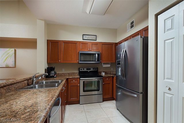 a kitchen with stainless steel appliances granite countertop a refrigerator stove and oven