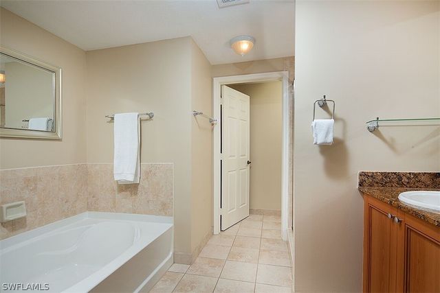 a bathroom with a tub sink and mirror