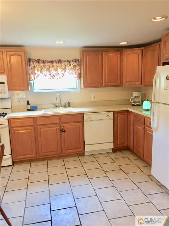 387 Middle Road Hazlet, NJ 07730 - Photo 3 of 20 a kitchen with a sink a stove a window and cabinets