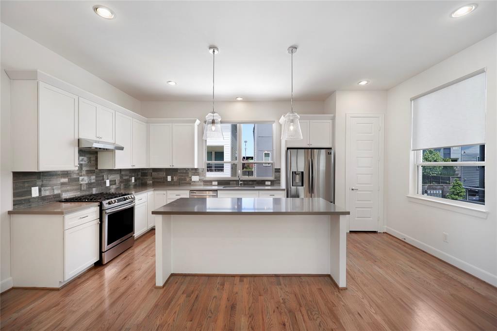 a large kitchen with stainless steel appliances kitchen island a large counter space a sink and appliances