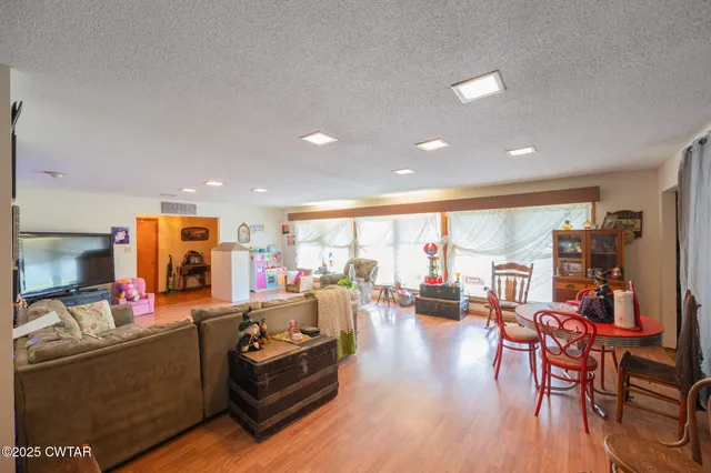 a living room with furniture kitchen view and a large window