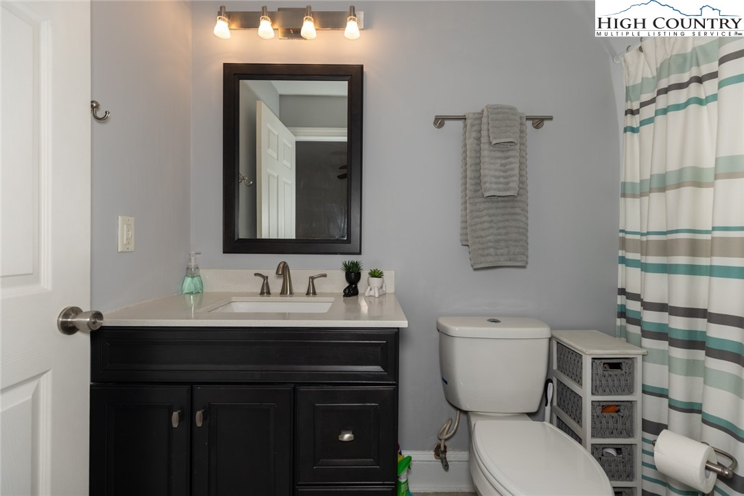 111 Peace Hill Road Fleetwood, NC 28626 - Photo 15 of 49 a bathroom with a toilet sink and mirror