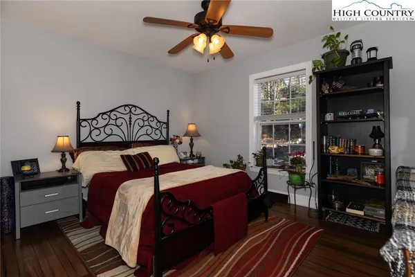 a bedroom with bed and wooden floor