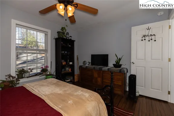 a room with a bed and a flat tv screen on the dresser
