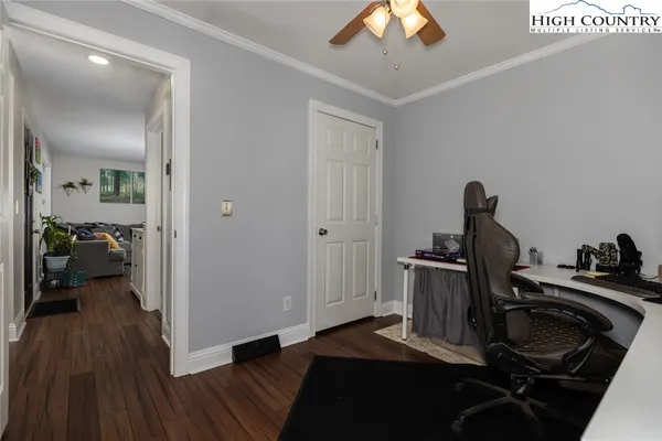 a view of a bedroom with a bed and wooden floor