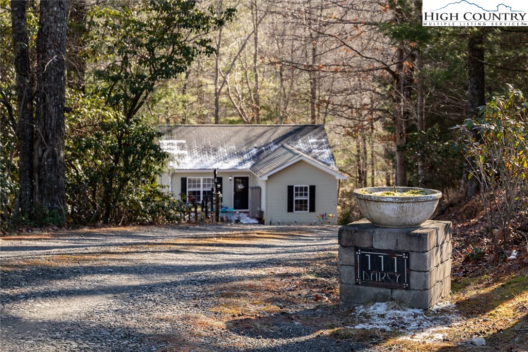 111 Peace Hill Road Fleetwood, NC 28626 - Photo 30 of 49 a view of a white house with a large tree and plants