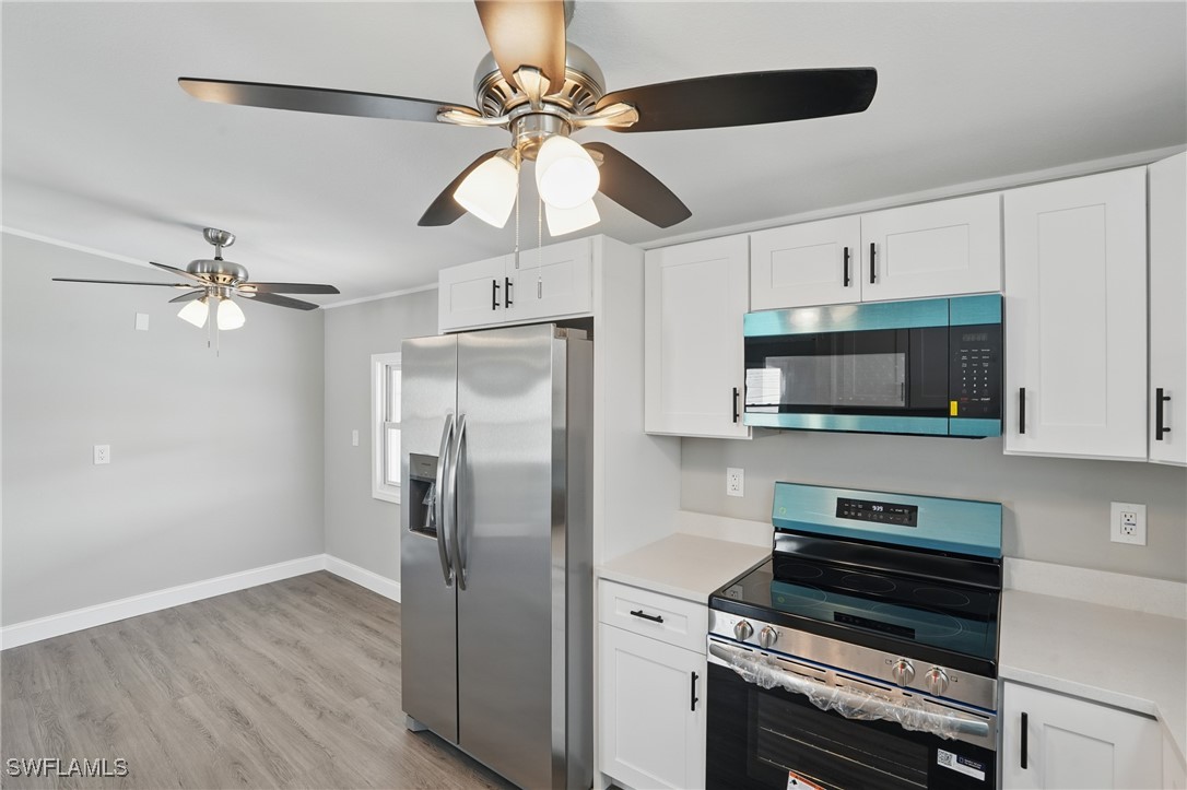 897 Manatee Road Naples, FL 34114 - Photo 12 of 36 a kitchen with stainless steel appliances a stove a refrigerator and a microwave