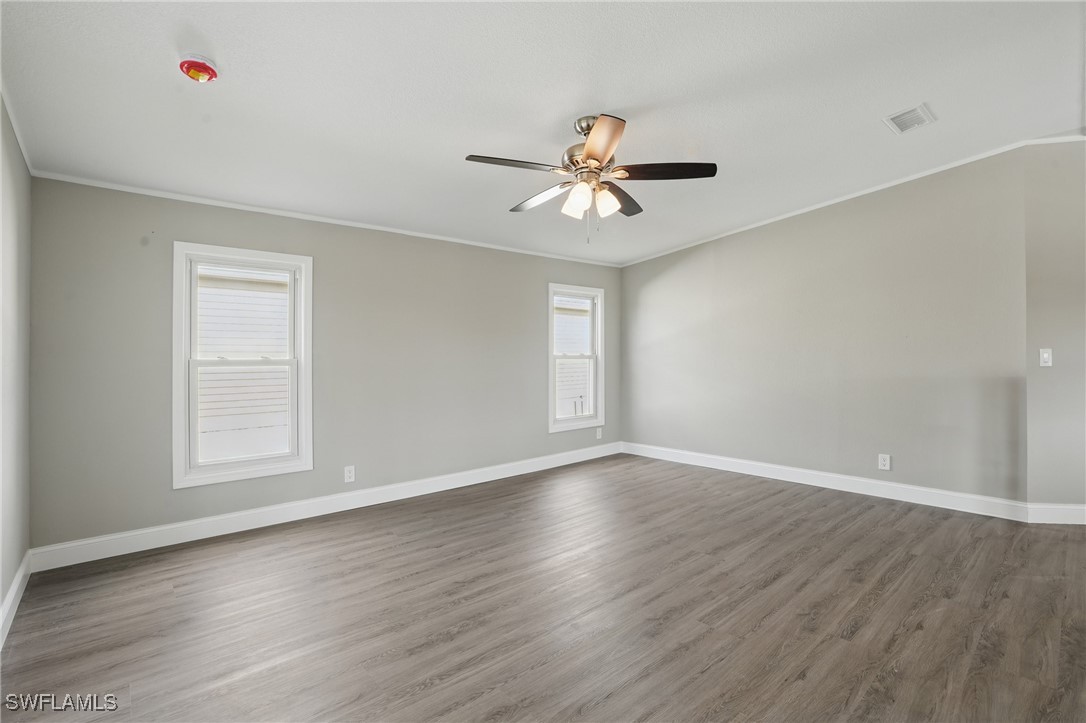 897 Manatee Road Naples, FL 34114 - Photo 13 of 36 a view of empty room with wooden floor and fan