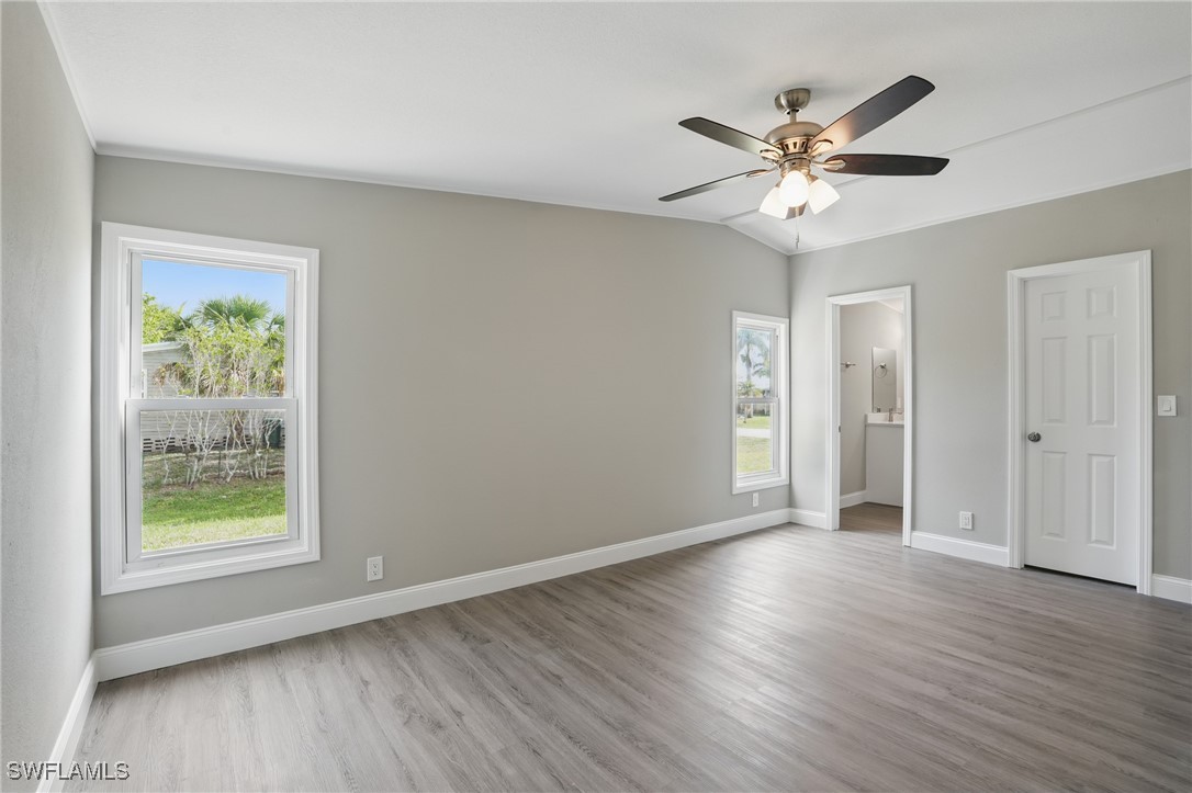 897 Manatee Road Naples, FL 34114 - Photo 16 of 36 a view of an empty room with wooden floor and a window