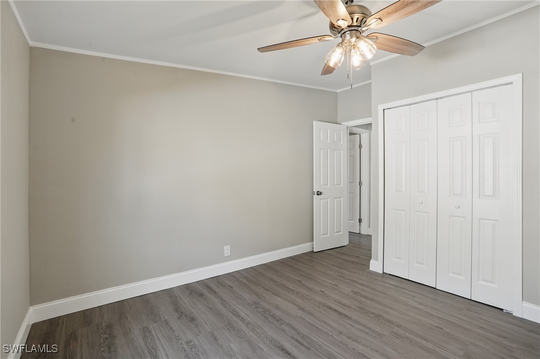 897 Manatee Road Naples, FL 34114 - Photo 20 of 36 an empty room with wooden floor closet and fan