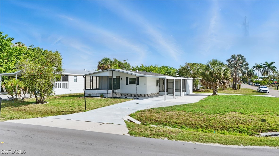 897 Manatee Road Naples, FL 34114 - Photo 30 of 36 a front view of a house with a yard