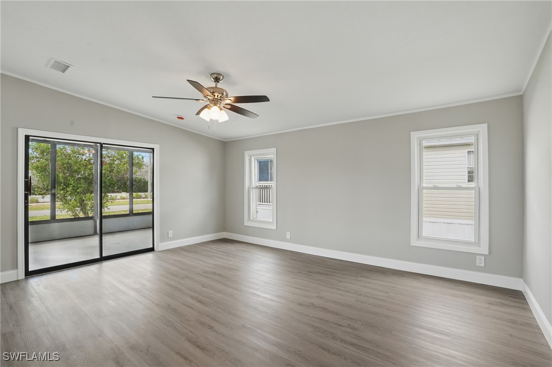 897 Manatee Road Naples, FL 34114 - Photo 5 of 36 a view of an empty room with a window and wooden floor