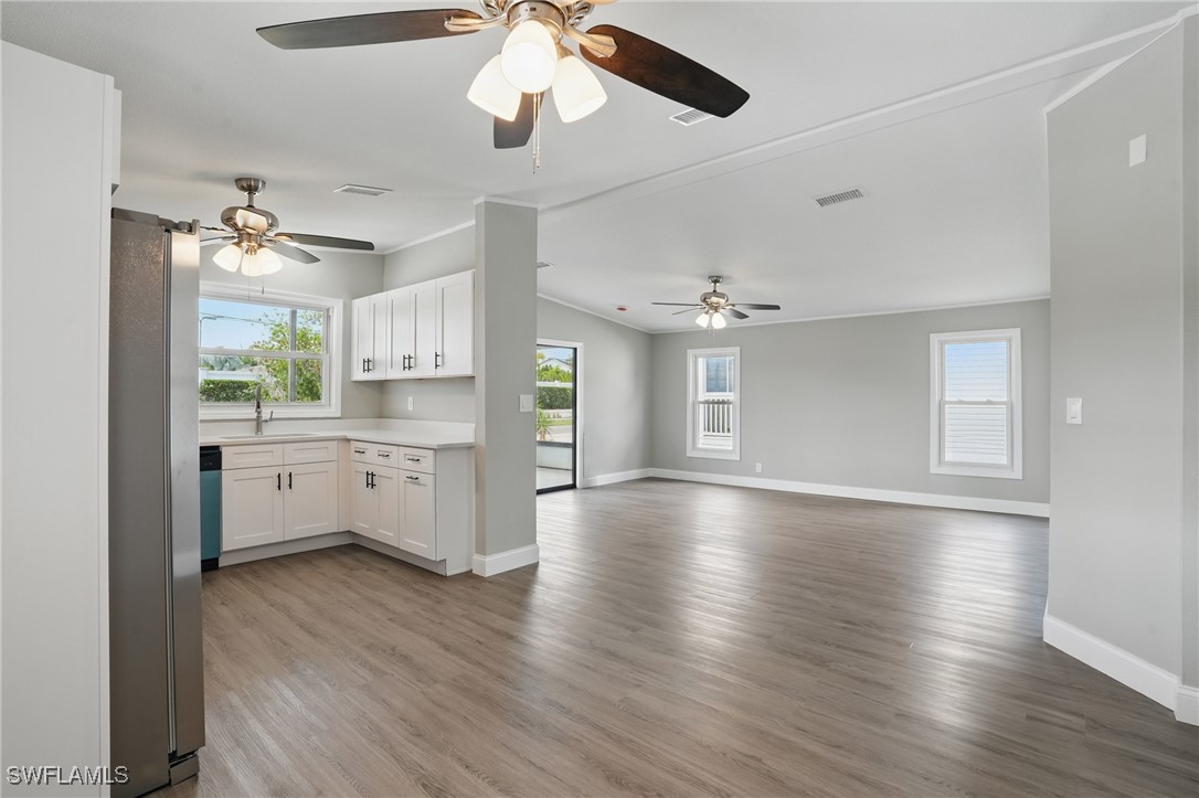 897 Manatee Road Naples, FL 34114 - Photo 6 of 36 a view of a kitchen with a sink dishwasher a stove and kitchen island with wooden floor