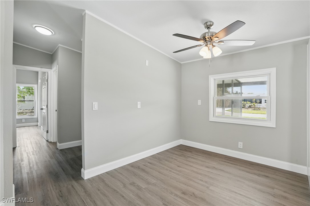 897 Manatee Road Naples, FL 34114 - Photo 8 of 36 a view of an empty room with wooden floor and a window