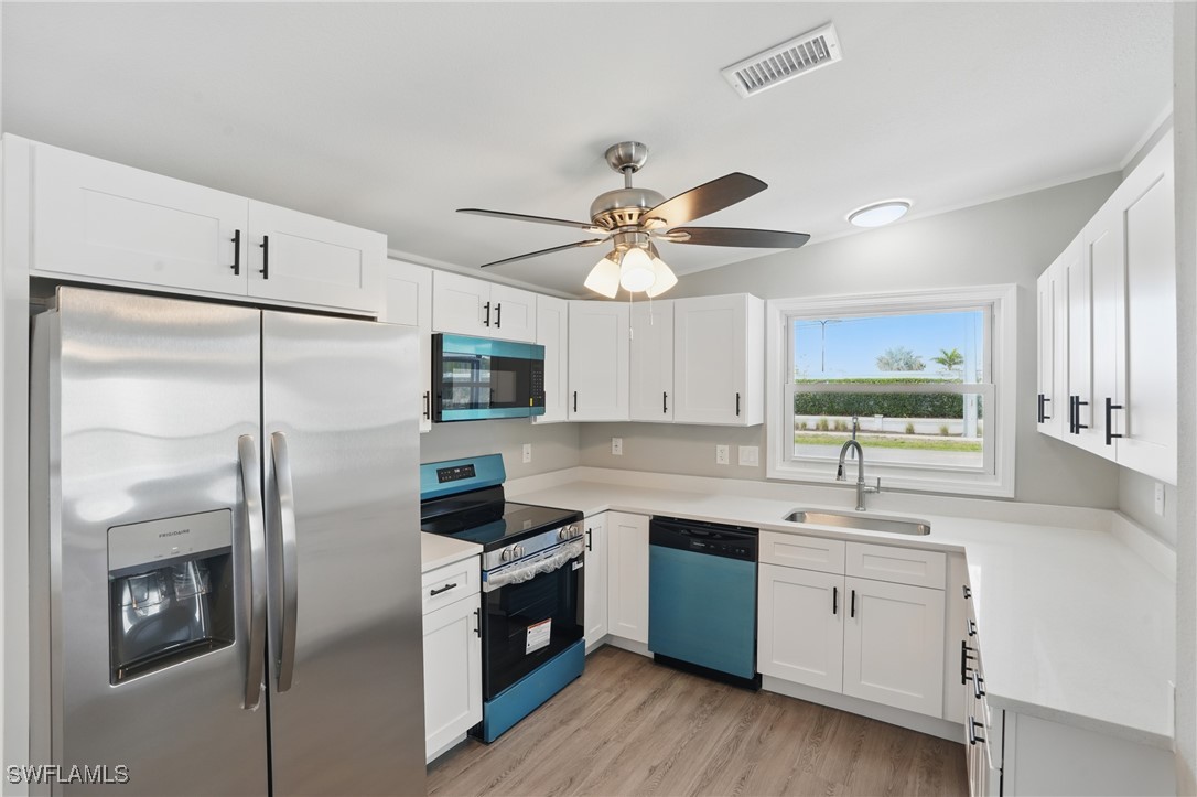 897 Manatee Road Naples, FL 34114 - Photo 9 of 36 a kitchen with a sink stainless steel appliances cabinets and a window