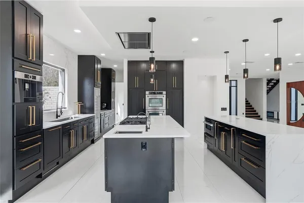 a spacious bedroom with a large bed and a chandelier