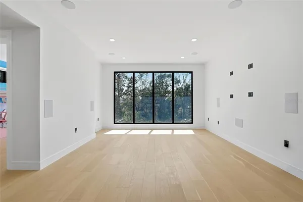 a view of a big room with wooden floor and windows