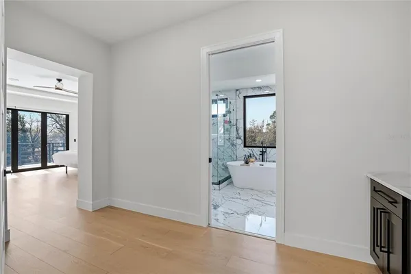 a view of a big room with wooden floor and windows