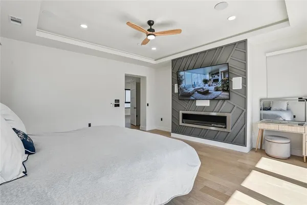 a bedroom with a large bed and a wooden floor