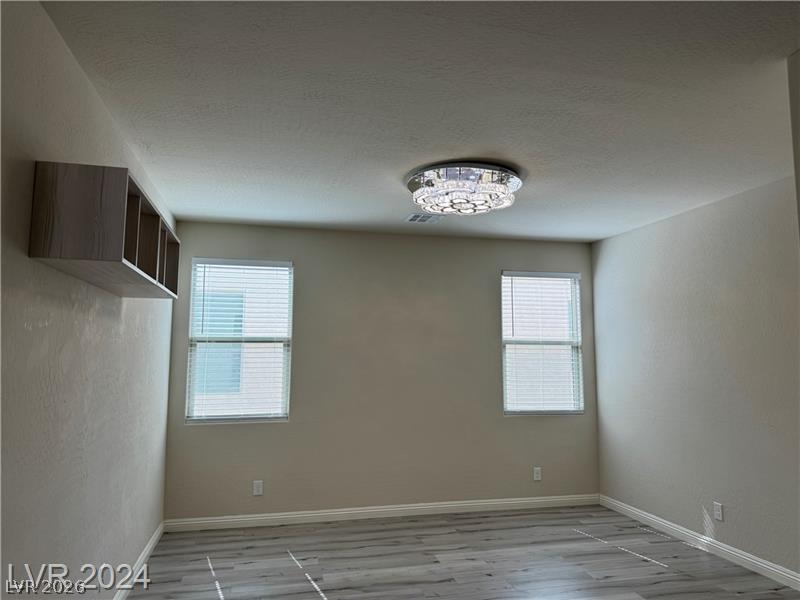 9056 Tony Ridge Avenue Las Vegas, NV 89148 - Photo 12 of 32 Tasteful plank flooring and recessed lighting define this well-lit secondary room.