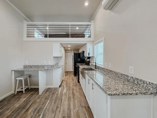 a bathroom with a granite countertop toilet a sink and a shower