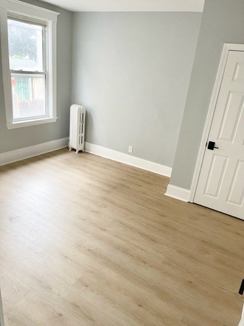 38 Oneida Street, Unit 2 Lynn, MA 01902 - Photo 12 of 22 an empty room with wooden floor and windows
