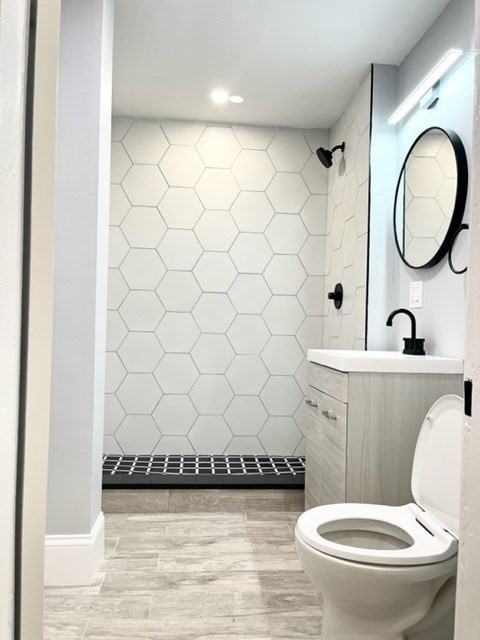 38 Oneida Street, Unit 2 Lynn, MA 01902 - Photo 14 of 22 a white toilet sitting next to a bathroom sink