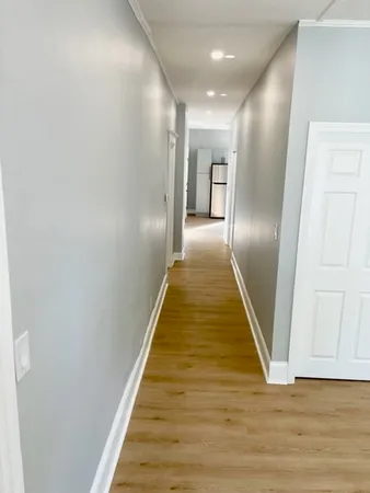 a view of a hallway with wooden floor