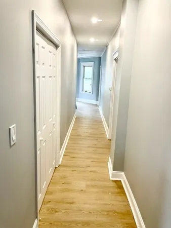 a view of a hallway with wooden floor and staircase