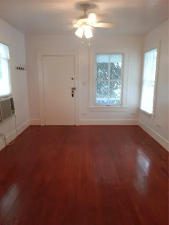 an empty room with a window and a fan