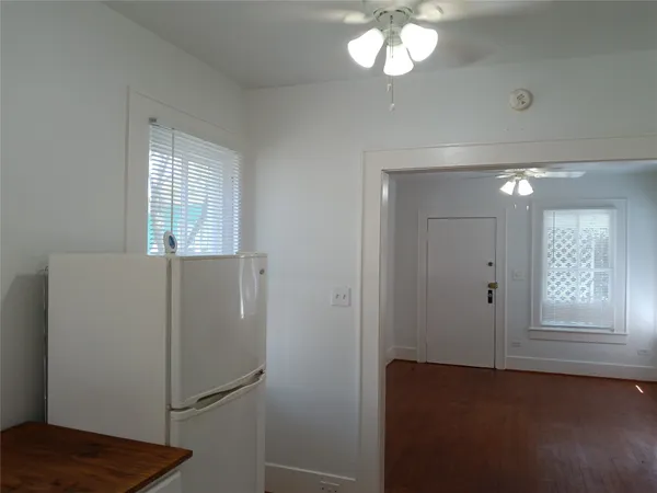 a view of an empty room with window and wooden floor