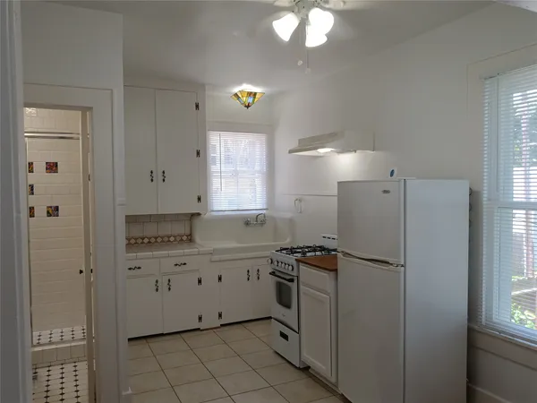 a kitchen with white cabinets and white appliances