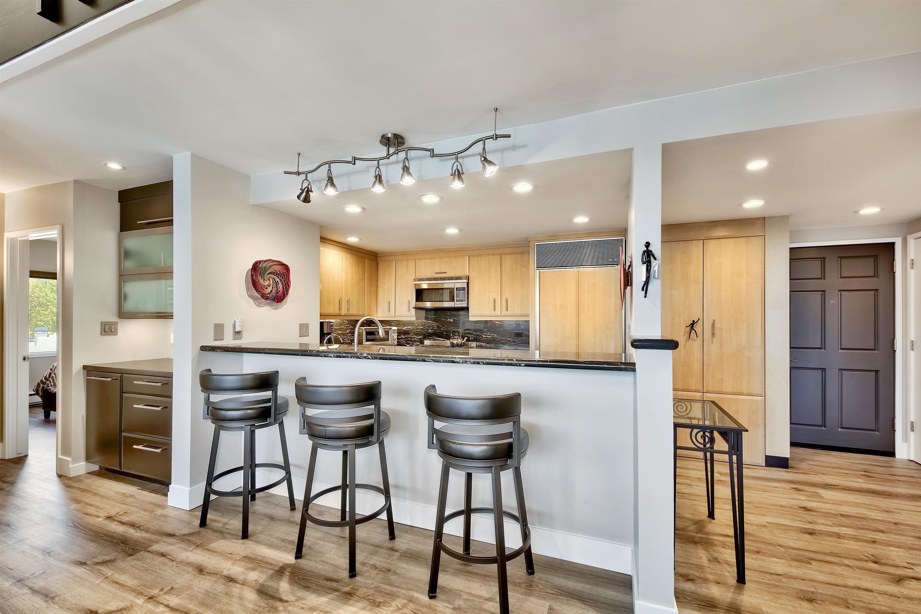 9200 Brockway Springs Drive, Unit 72 Kings Beach, CA 96143 - Photo 9 of 21 a kitchen with stainless steel appliances kitchen island granite countertop a table chairs refrigerator and microwave
