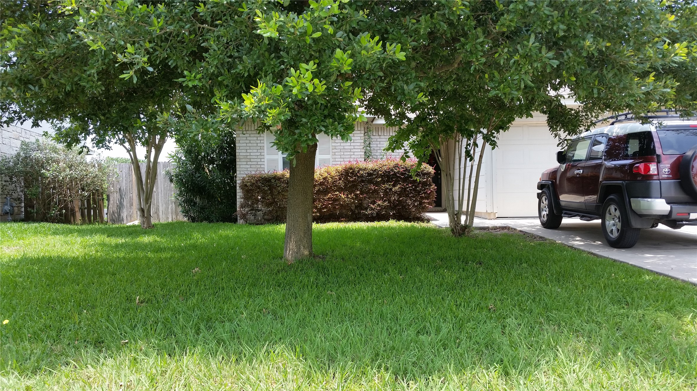 196 Goddard Kyle, TX 78640 - Photo 1 of 1 Mature trees frame the appealing brick facade of this welcoming residence.